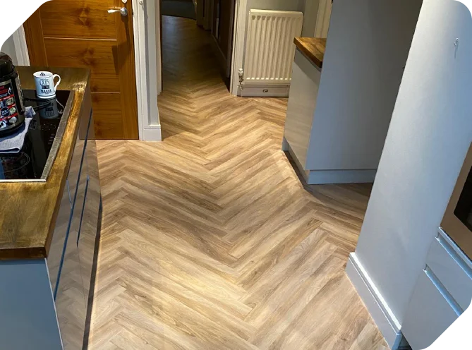 Herringbone plank flooring fitted through a hallway and kitchen
